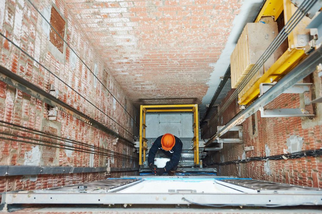 Técnico fazendo manutenção em elevador de condomínio