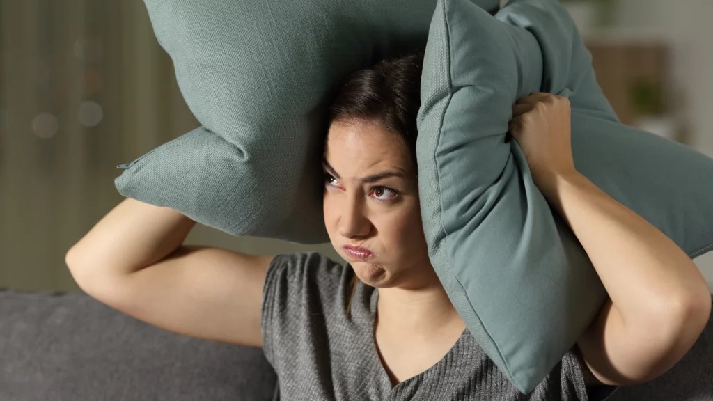 Mulher irritada com barulhos em seu condomínio